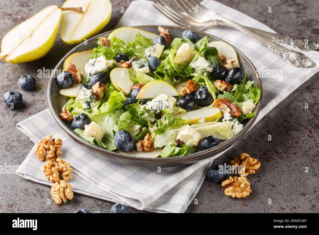 Insalata gourmet con pere dolci, mirtilli, formaggio blu, lattuga e noci da vicino in un piatto sul tavolo. Orizzontale Foto Stock