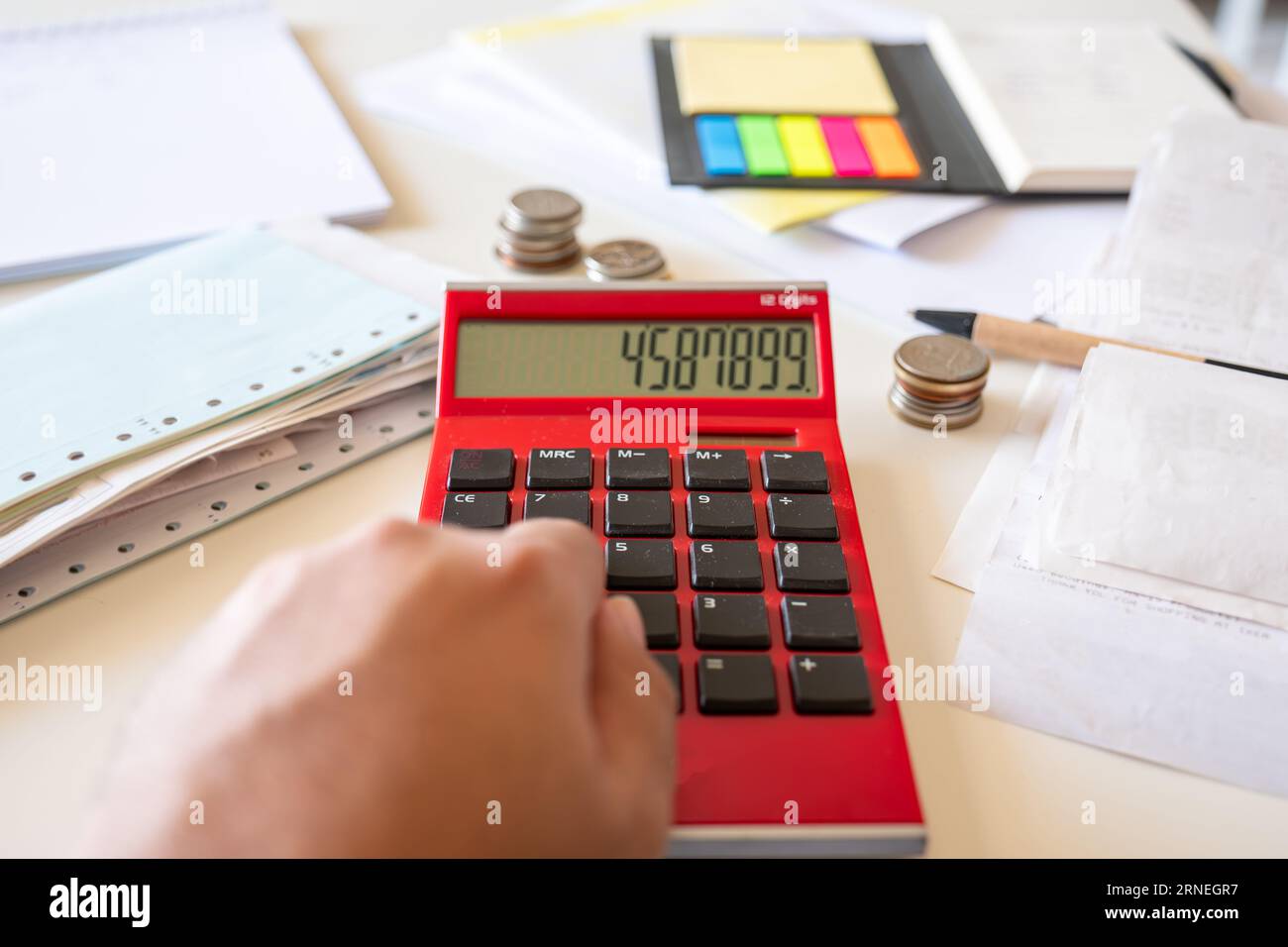 Mani d'uomo con bollette finanziarie che calcolano con calcolatrice Foto Stock
