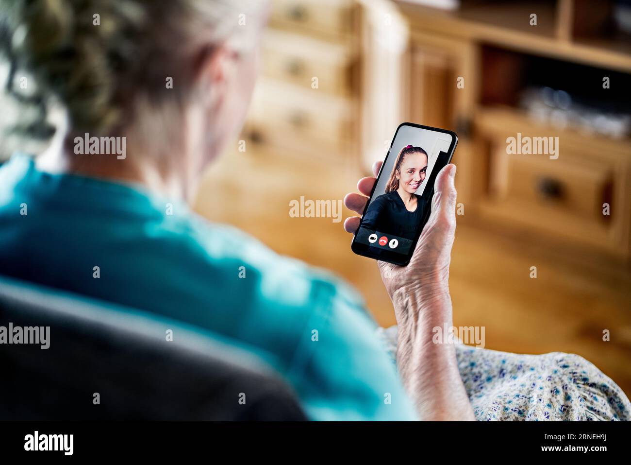 Vecchia donna anziana che ha una videochiamata telefonica con la giovane donna. Comunicazione familiare. Tecnologia mobile. Nonna che usa la videocall per smartphone. Foto Stock