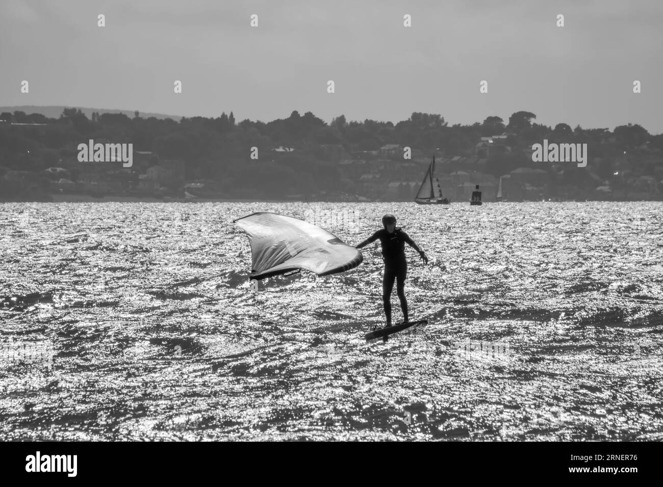 Hill Head Inghilterra - 20 agosto 2023: Windsurf in bianco e nero con l'Isola di Wight sullo sfondo Foto Stock