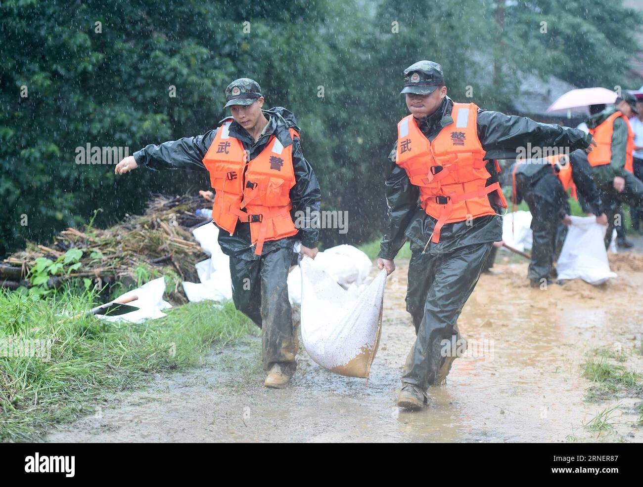 (160702) -- ANQING, 2 luglio 2016 -- gli agenti di polizia armati portano un sacco di sabbia e vanno in soccorso nel villaggio Mingfeng della contea di Huaining nella città di Anqing, nella provincia di Anhui della Cina orientale, 2 luglio 2016. A causa delle forti piogge, i soccorritori sono stati inviati per evacuare i residenti intrappolati nelle inondazioni di Anqing City sabato. (Wyl) CHINA-ANHUI-FLOOD-RESCUE (CN) GuoxChen PUBLICATIONxNOTxINxCHN 160702 Anqing 2 luglio 2016 gli agenti di polizia armati portano un sacco di sabbia e vanno in soccorso nel villaggio di Huaining County nella città di Anqing nella provincia di Anhui della Cina orientale 2 luglio 2016 a causa di Heavy Rainfall Rescue sono stati inviati per evacuare re Foto Stock