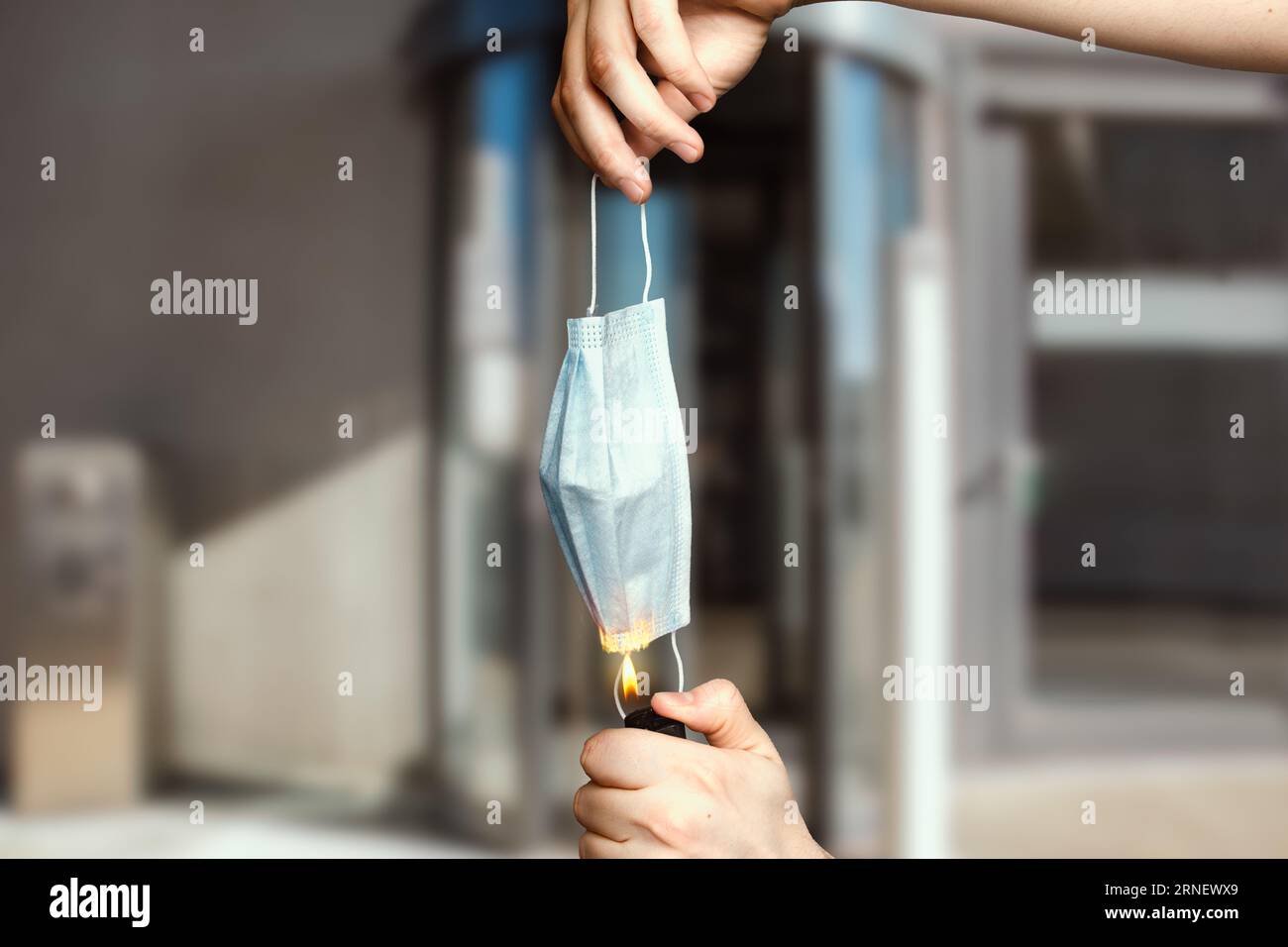 Bruciare maschera medica per terminare le misure corona come simbolo contro le norme del governo federale dopo rifiutato l'ingresso all'ingresso di edificio bruciato Foto Stock