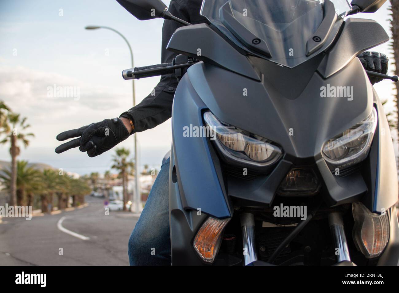 Primo piano del tipico saluto tra motociclisti: Rimanete su due ruote, amico mio Foto Stock