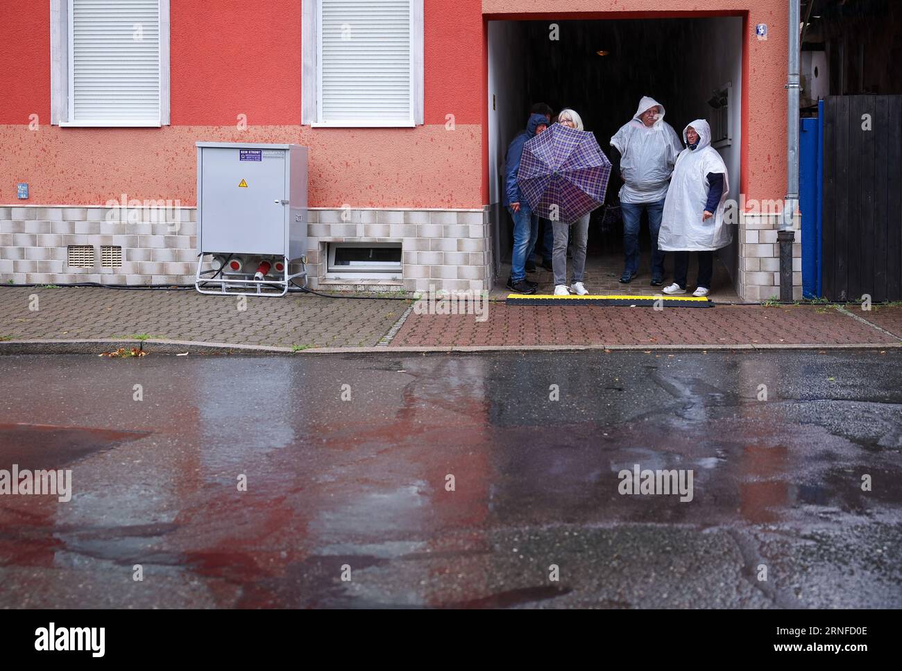 Aue Bad Schlema, Germania. 1 settembre 2023. I visitatori cercano riparo dalla pioggia durante l'apertura del "giorno dei sassoni". Per la prima volta dal 2019, il più grande festival di storia locale e associazioni nello Stato libero sarà celebrato di nuovo all'inizio di settembre. Dal 1° al 3 settembre a Aue sono attesi circa 180.000 visitatori. Le attrazioni includono una grande parata la domenica pomeriggio. Inoltre, tutti i visitatori dovranno cantare lo Steigerlied, l'inno segreto dei Monti ore, sabato alle 18.00, praticamente come un grande coro. Crediti: Jan Woitas/dpa/Alamy Live News Foto Stock