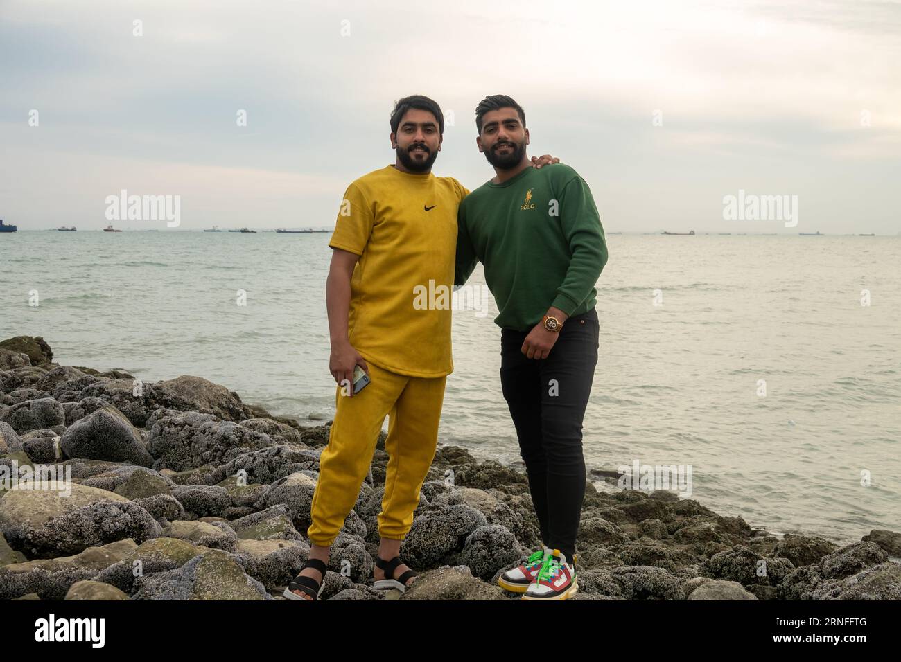 Bandar Abbas, Iran - 3 gennaio 2023: Giovani iraniani (compagni) sullo stretto di Hormuz, vestiti di moda europea. Occidentalizzazione globale Foto Stock