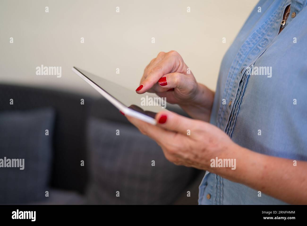 Donna di mezza età irriconoscibile con un tablet. Concetto di donne anziane e nuove tecnologie. Donna anziana che utilizza un tablet digitale. Foto Stock