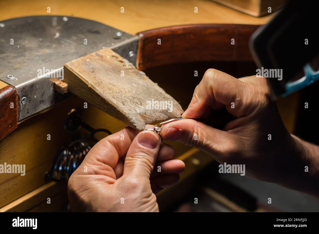 Mani di un gioielliere artigianale che lavora gioielli. Gioielleria Goldsmith Foto Stock