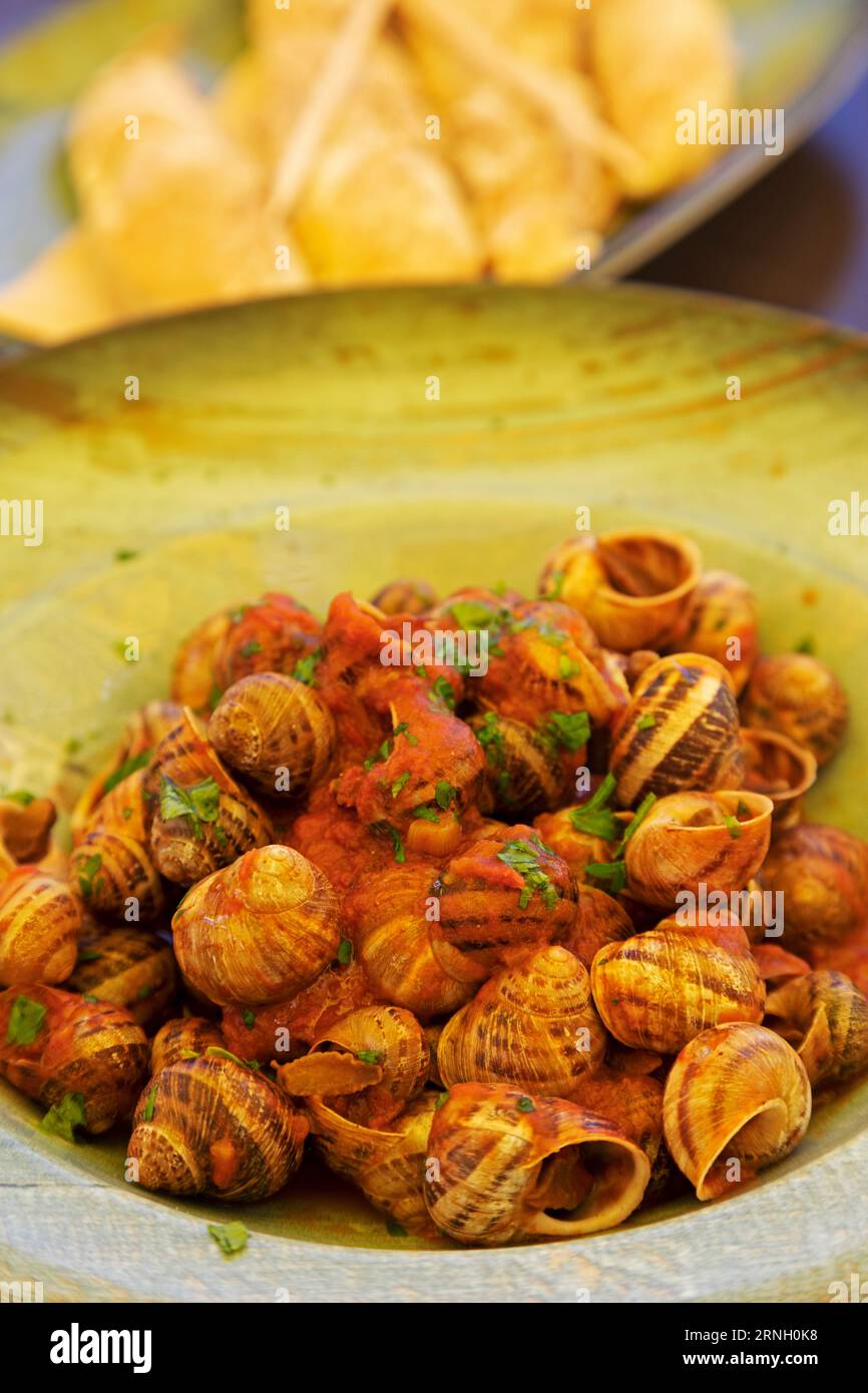 Lumache in salsa di pomodoro aglio servite per pranzo a Malta. Il piatto è conosciuto come bebbux bl-arjoli a Malta. Foto Stock