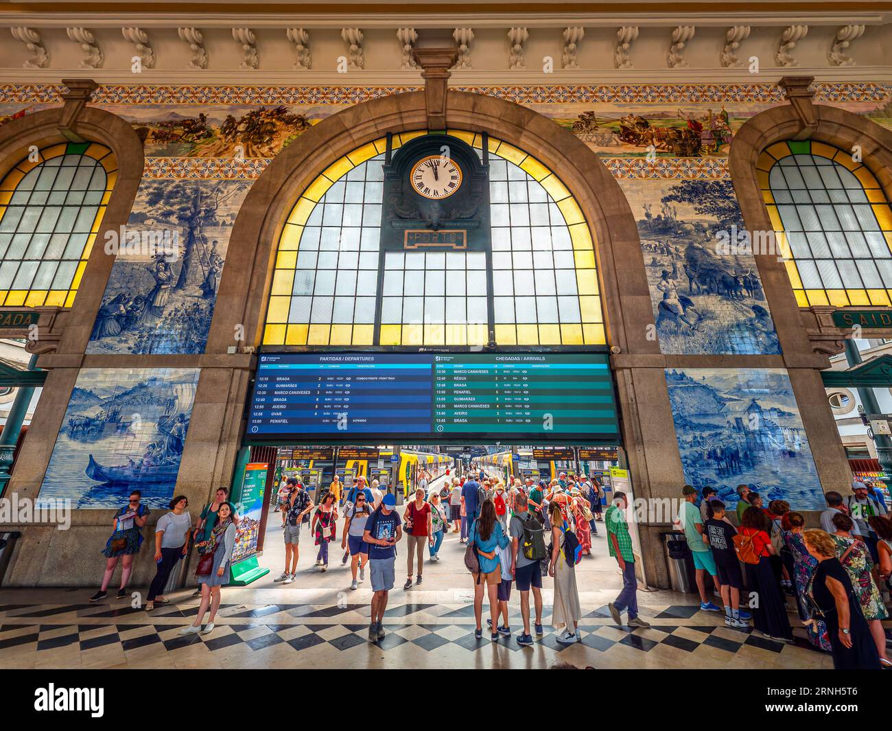 Porto, Portogallo, Europa - 26 giugno 2023: Vista interna della famosa stazione ferroviaria e del cancello ferroviario, con i turisti che si preparano e consultano il ti Foto Stock