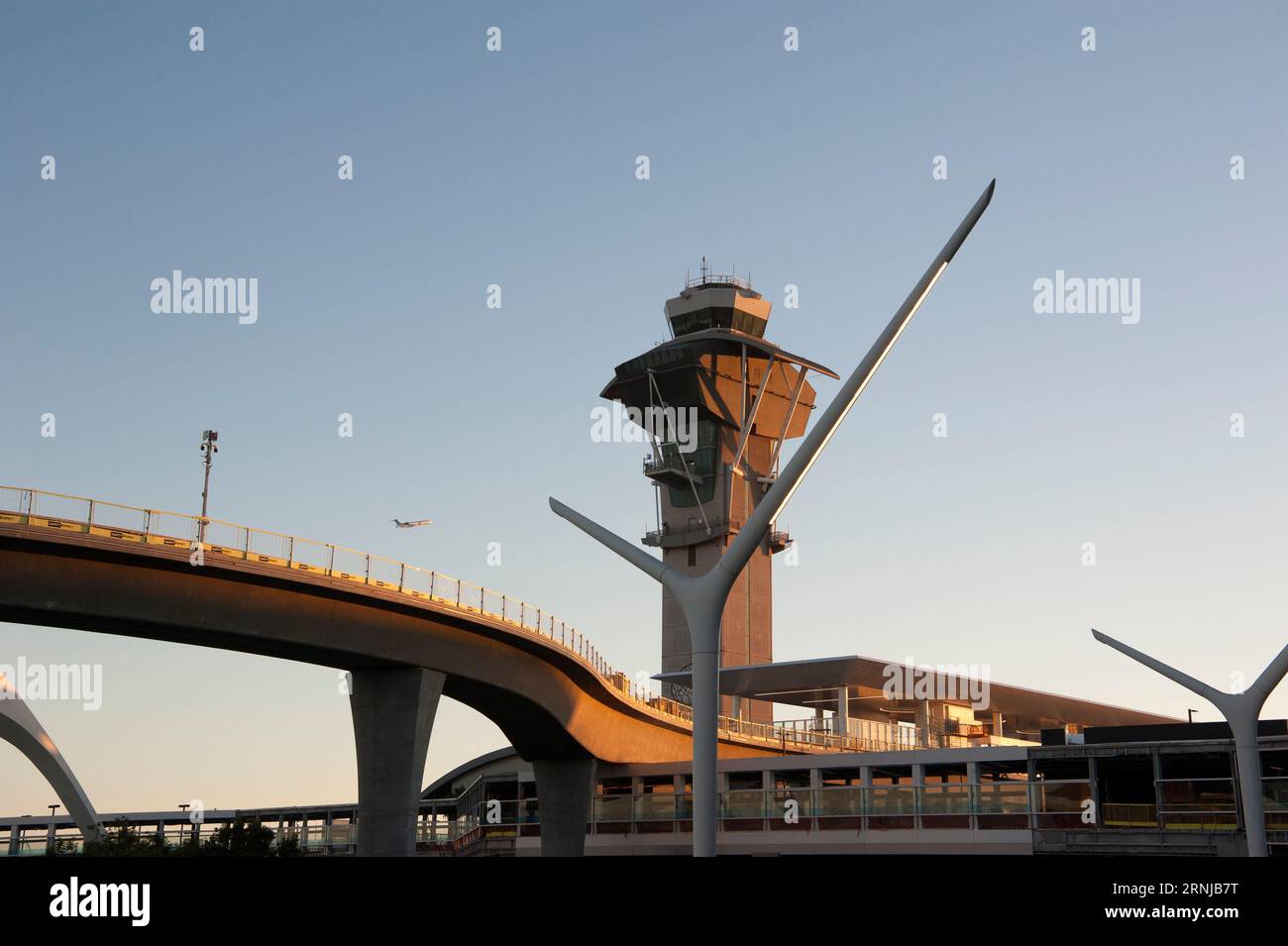 Un aereo in partenza dall'aeroporto internazionale di Los Angeles vola sui binari appena installati per la linea della metropolitana passando per l'iconico edificio a tema e la torre di controllo di Los Angeles, CALIFORNIA. Foto Stock