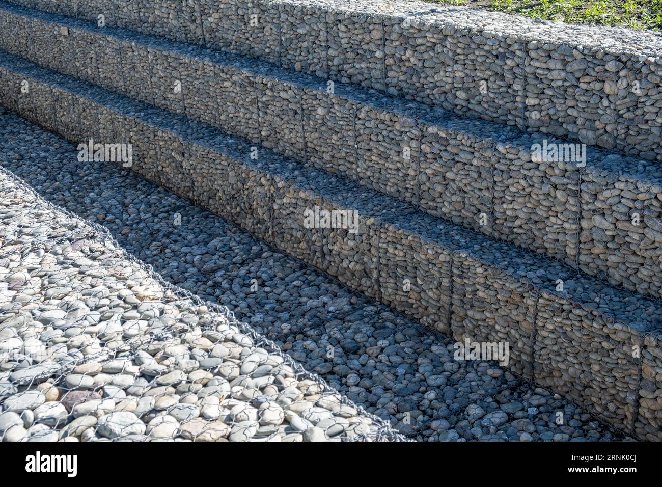 Una diga in pietra fatta di piccole pietre, che rinforza la riva Foto Stock