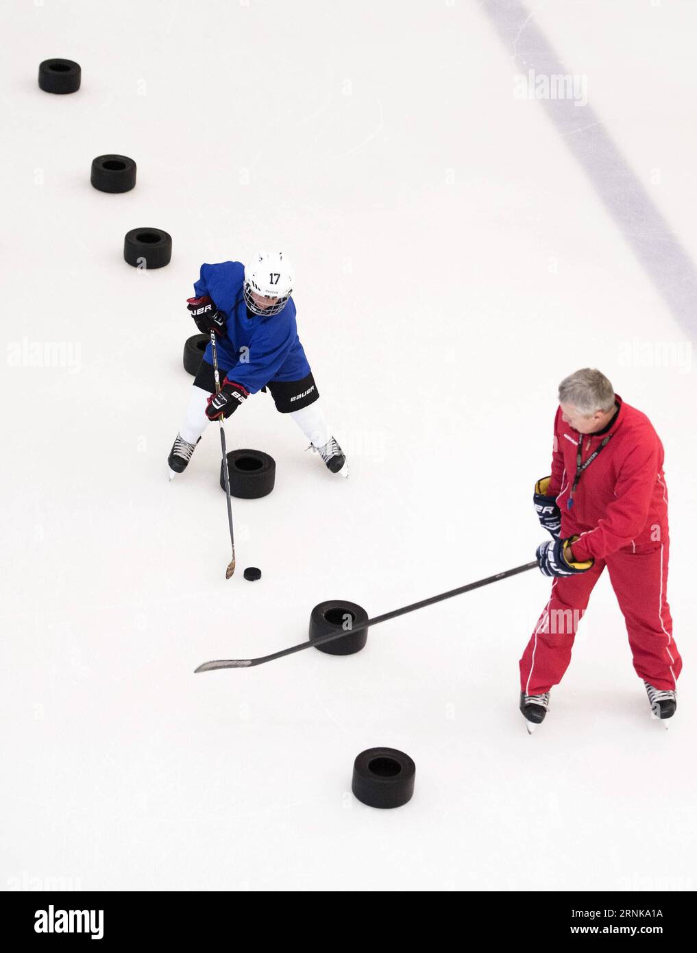 170316 -- WUHAN , 16 marzo 2017 -- la foto scattata il 25 febbraio 2017 mostra un giocatore di hockey su ghiaccio del Binglong International Skating Club che segue un allenamento sotto le istruzioni del suo allenatore russo Nikolaev Vladimir in una pista di pattinaggio in un centro commerciale a Wuhan, nella provincia di Hubei, nella Cina centrale. Mantenendo un ritmo di sviluppo solido e costante, l'industria sportiva cinese è in piena espansione nel 2016. Il programma nazionale di fitness 2016-2020 e il tredicesimo piano quinquennale sull'industria sportiva sono stati entrambi pubblicati nel 2016 per offrire una chiara direzione alla strategia nazionale cinese di garantire l'idoneità pubblica e lo sviluppo Foto Stock