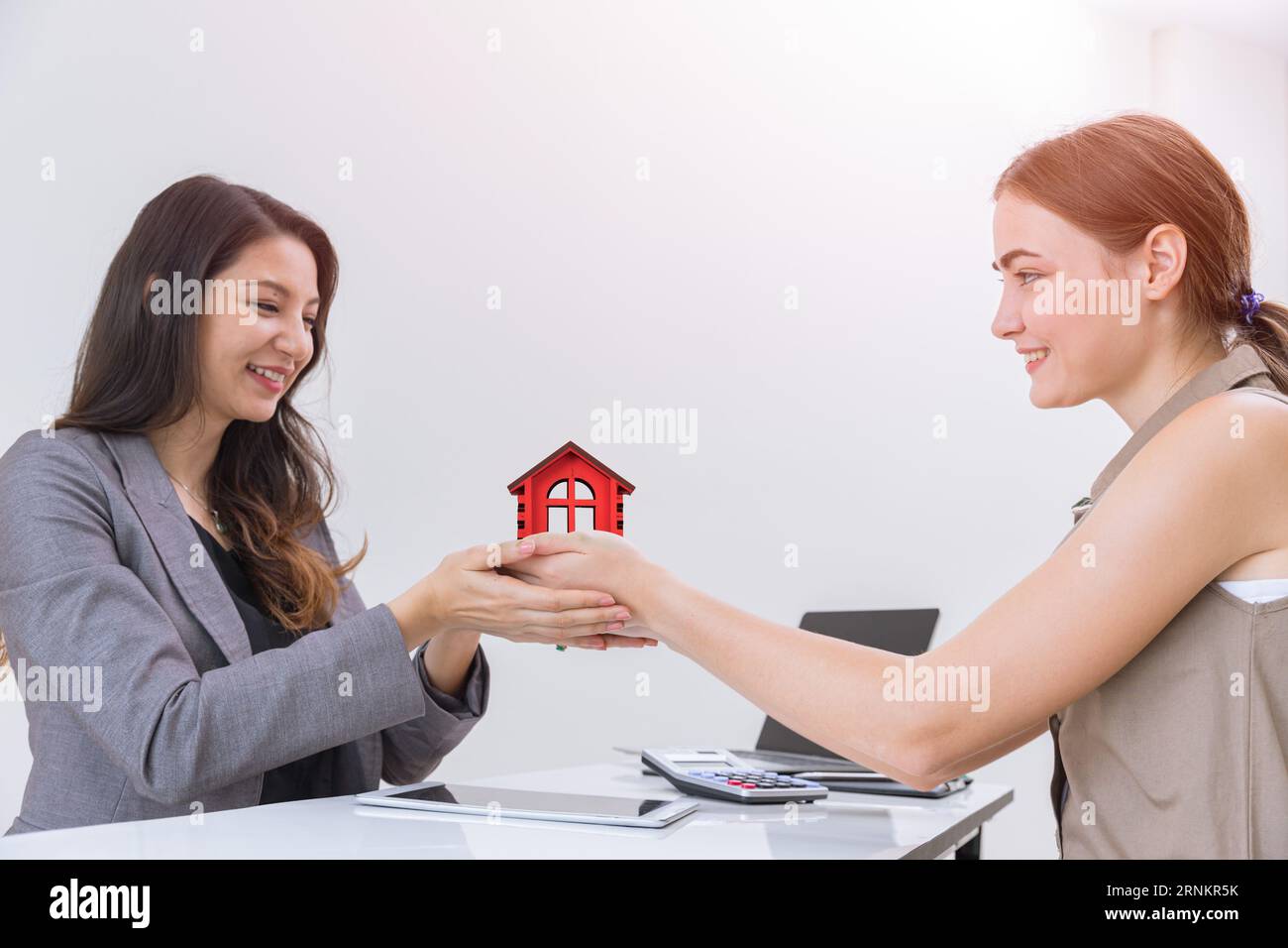 L'offerta di servizi aziendali per agenti di vendita immobiliari offre ai clienti un sorriso felice Foto Stock