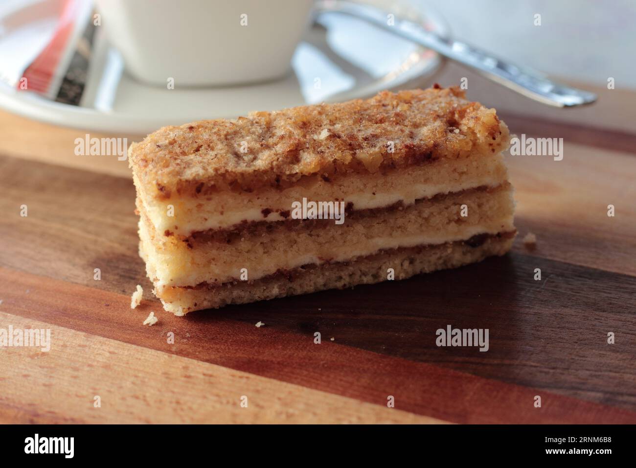 Fetta di torta a strati di noce, strati di spugna riempita con marmellata e panna con condimento in noce e albume d'uovo Foto Stock