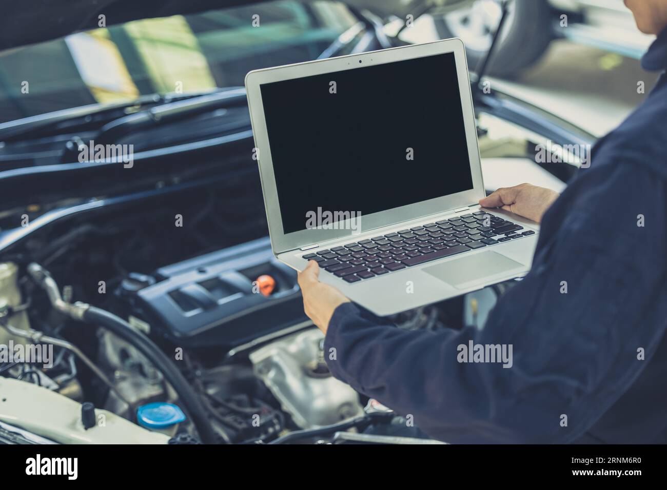 Schermo vuoto per computer portatile con ECU delle prestazioni del motore di un'auto moderna messa a punto nel concetto di officina auto-garage Foto Stock