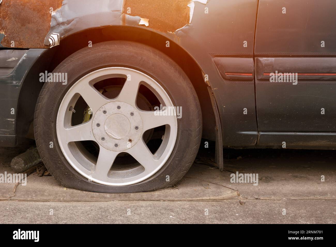 parcheggio all'aperto per auto con pneumatici sgonfi in caso di clima caldo, il vecchio veicolo rotto danneggiato deve essere sottoposto a manutenzione Foto Stock
