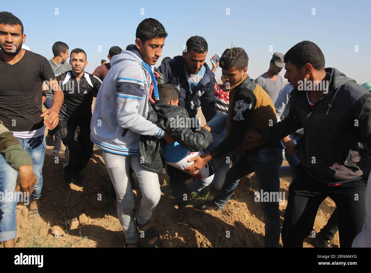 (170519) -- GAZA, 19 maggio 2017 -- i manifestanti palestinesi trasportano un uomo ferito durante gli scontri con soldati israeliani a seguito di una protesta contro il blocco a Gaza vicino alla recinzione di confine a est di Khan Younis nella Striscia di Gaza meridionale, il 19 maggio 2017. Dozzine di giovani palestinesi si sono scontrati venerdì pomeriggio con soldati dell'esercito israeliano di stanza nella zona di confine tra la Striscia di Gaza orientale e Israele, almeno otto feriti, hanno detto i medici. ) MIDEAST-GAZA-CLASH KhaledxOmar PUBLICATIONxNOTxINxCHN Gaza 19 maggio 2017 i manifestanti PALESTINESI trasportano un uomo ferito durante gli scontri con soldati israeliani Foto Stock