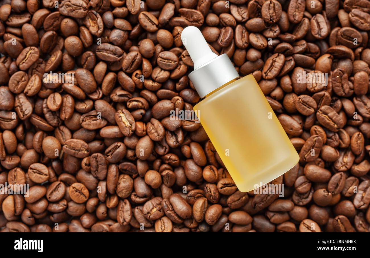 Siero oculare con caffeina per la cura della pelle. Bottiglia del prodotto e chicchi di caffè. Caffeina per la cura della pelle. Foto Stock