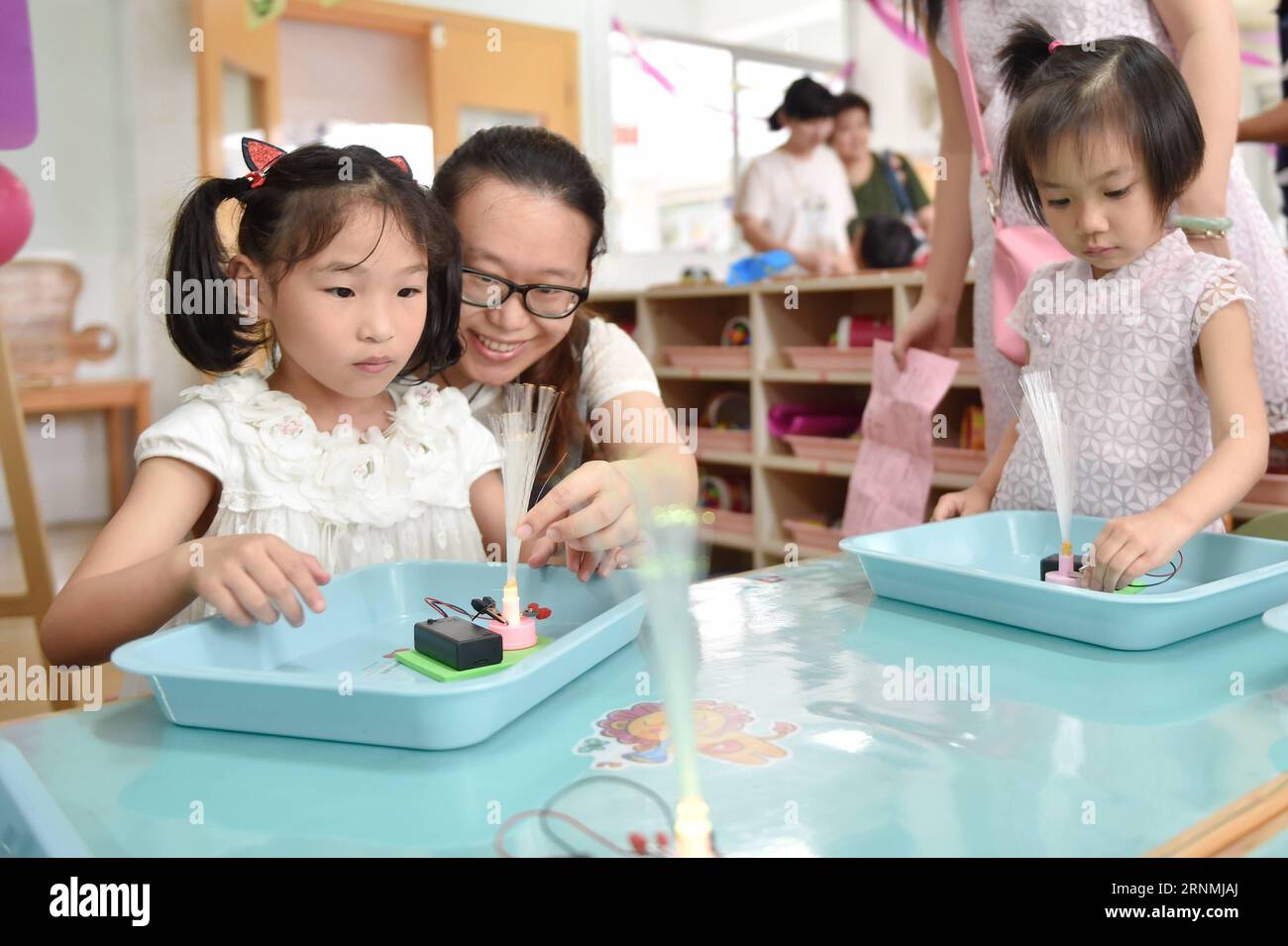 (170531) -- FUZHOU, 31 maggio 2017 -- un adulto aiuta un bambino in un esperimento LED in un asilo affiliato al Fujian Preschool Education College di Fuzhou, capitale della provincia del Fujian della Cina sudorientale, 31 maggio 2017. Con i bambini e i loro familiari invitati, è stata organizzata una festa nell'asilo per celebrare la prossima giornata internazionale dei bambini e per migliorare le loro capacità di creazione. ) (zhs) CHINA-FUZHOU-CHILDREN S DAY (CN) SongxWeiwei PUBLICATIONxNOTxINxCHN Fuzhou maggio 31 2017 ad Adult Helps a Child ON to LED Experiment in a Kindergarten Affiliated to Fujian Preschool Educat Foto Stock