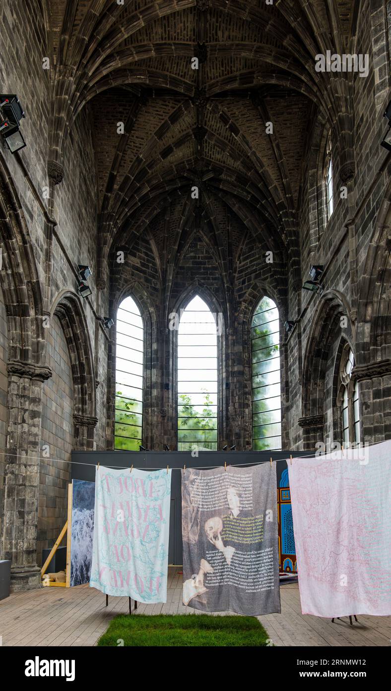 Un'installazione di impiccagioni nell'edificio della vecchia chiesa con finestre ad arco, abside della Trinità, Edimburgo, Scozia, Regno Unito Foto Stock