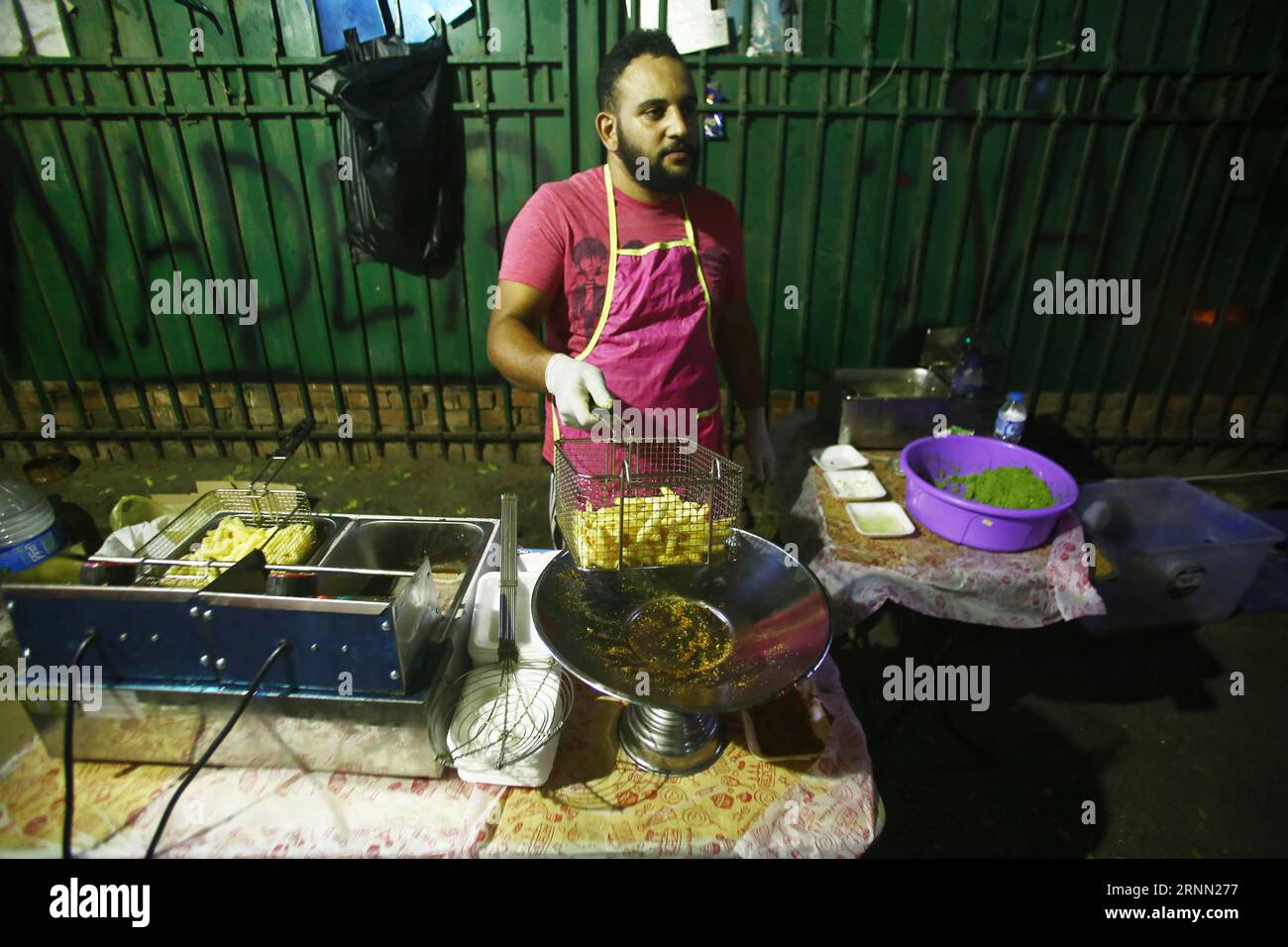 (170620) -- CAIRO, 20 giugno 2017 -- un giovane egiziano prepara il cibo in un Bean Cart, un piccolo stand di Street food che serve il tradizionale pasto pre-digiuno, noto come Suhur, durante il mese santo musulmano del Ramadan, sul marciapiede nel sobborgo di Heliopolis al Cairo, in Egitto, il 19 giugno 2017. I carretti dei fagioli unici sono gestiti da un gruppo di giovani egiziani altamente istruiti, che sperano di utilizzare parte delle entrate per attività di beneficenza. Lo scopo principale di avviare questo progetto lo scorso anno è Hussein Hamza, un cofondatore del progetto di 30 anni, ha detto a Xinhua. Il gruppo lavora solo durante Ramada Foto Stock