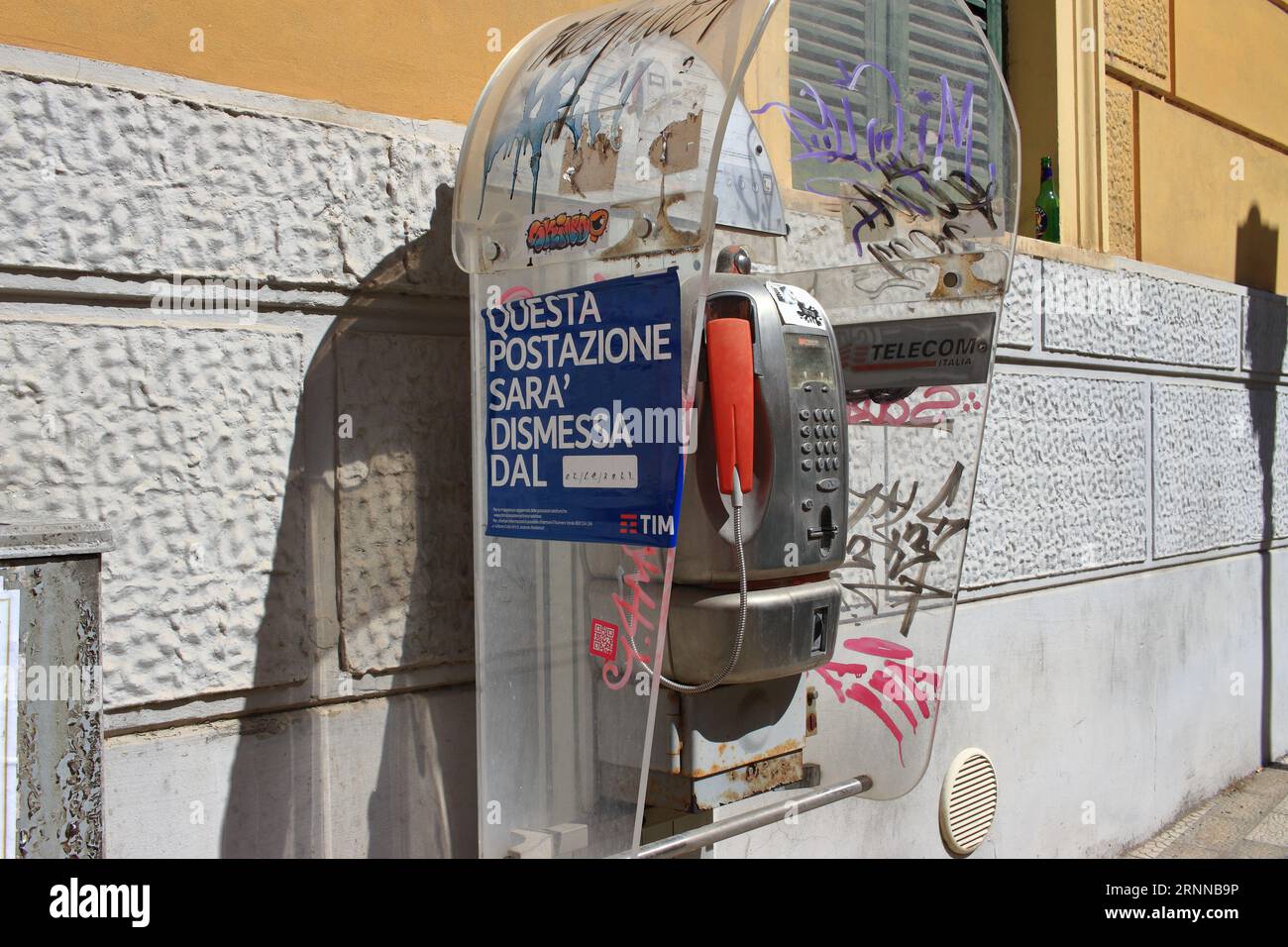 Un vecchio telefono pubblico funziona con monete e schede telefoniche nelle strade del centro storico. Entro la fine del 2023, il TIM italiano li rimuoverà. Foto Stock