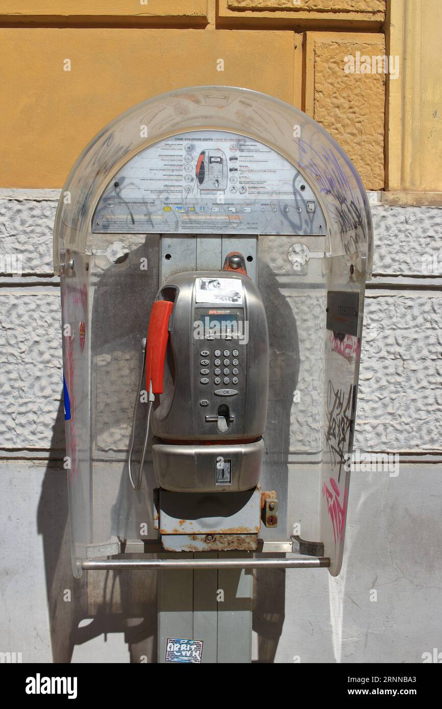Un vecchio telefono pubblico funziona con monete e schede telefoniche nelle strade del centro storico. Entro la fine del 2023, il TIM italiano li rimuoverà. Foto Stock