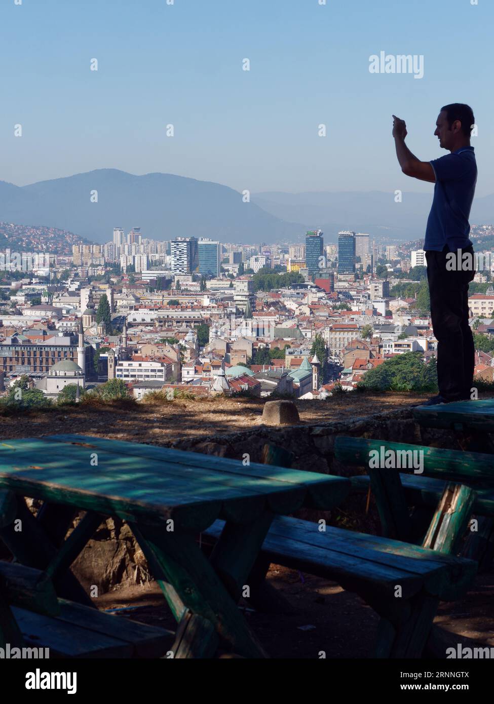 Vista sopraelevata dal forte giallo sulla città di Sarajevo, con tavoli da picnic e uomo che scatta foto, Bosnia ed Erzegovina, 2 settembre 2023 Foto Stock
