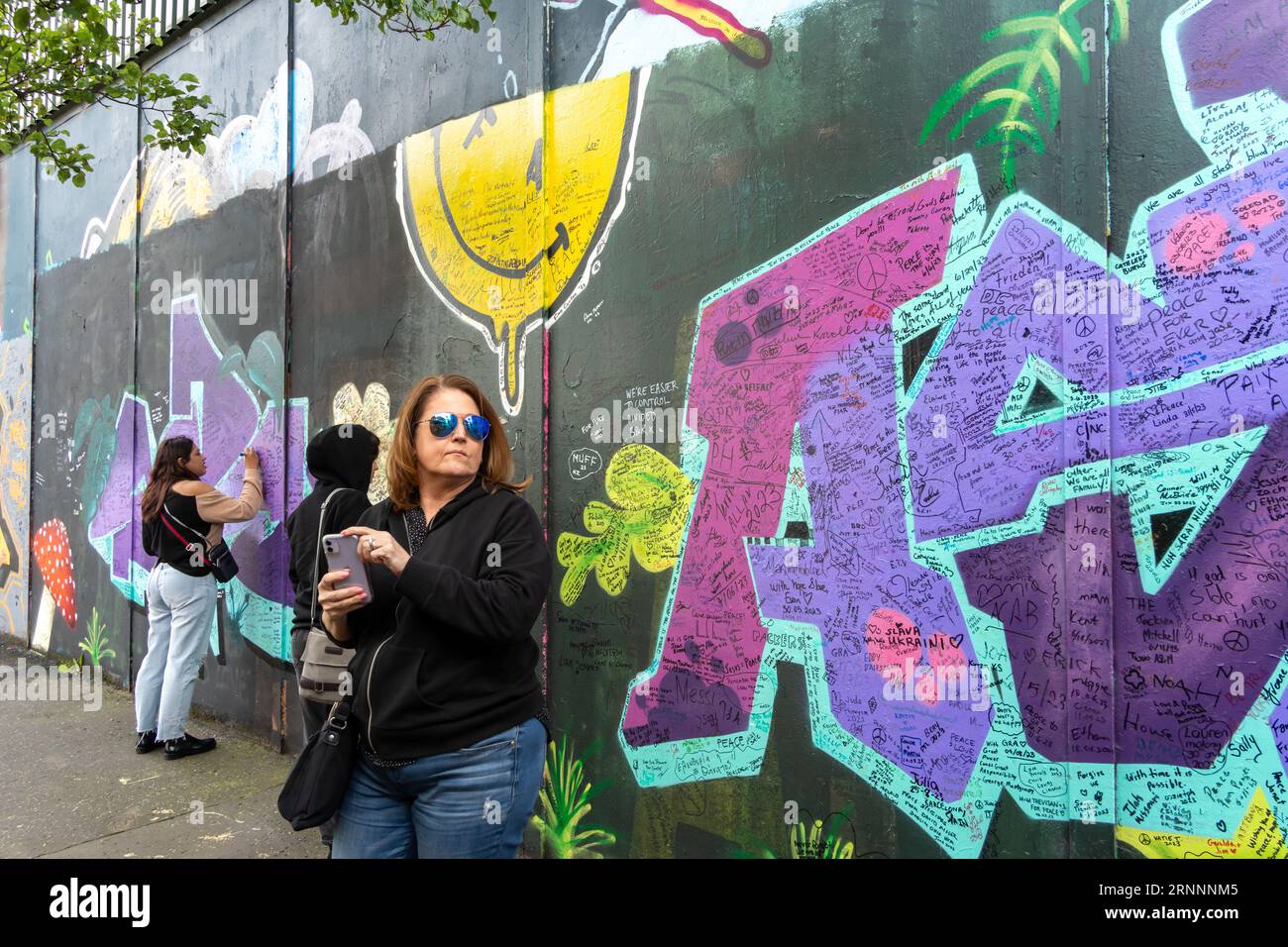 La gente firma il muro della Pace, Cooper Way, Belfast, Irlanda del Nord Foto Stock