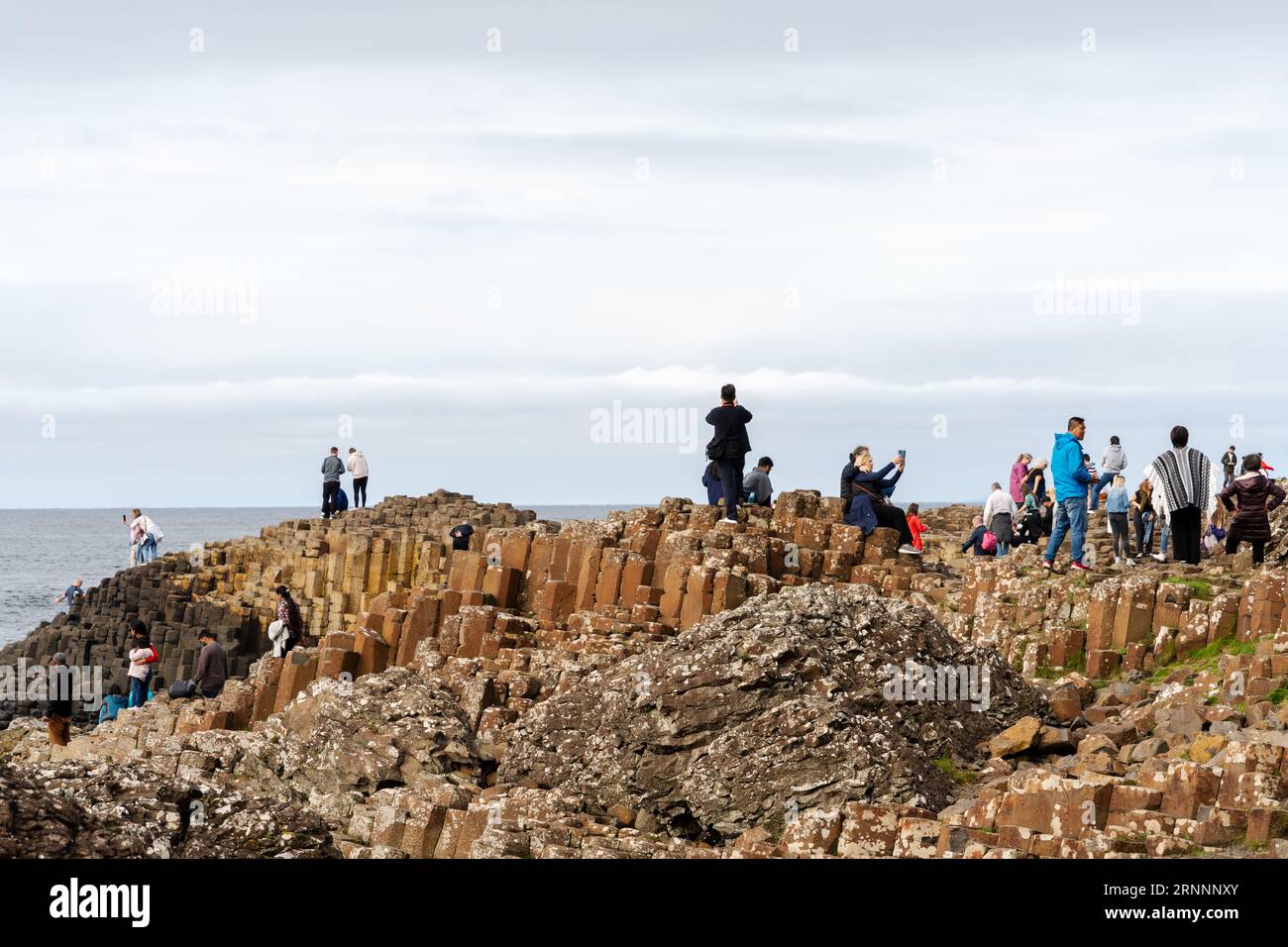 Selciato del gigante, vicino a Bushmills, Irlanda del Nord. I visitatori delle formazioni rocciose naturali di basalto, che sono una popolare attrazione turistica. Foto Stock