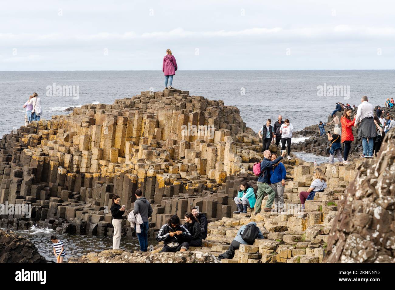 Selciato del gigante, vicino a Bushmills, Irlanda del Nord. I visitatori delle formazioni rocciose naturali di basalto, che sono una popolare attrazione turistica. Foto Stock