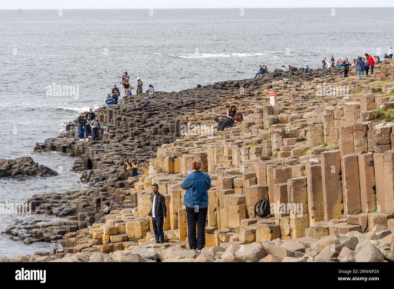 Selciato del gigante, vicino a Bushmills, Irlanda del Nord. I visitatori delle formazioni rocciose naturali di basalto, che sono una popolare attrazione turistica. Foto Stock