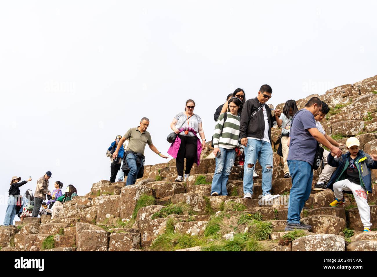 Selciato del gigante, vicino a Bushmills, Irlanda del Nord. I visitatori delle formazioni rocciose naturali di basalto, che sono una popolare attrazione turistica. Foto Stock