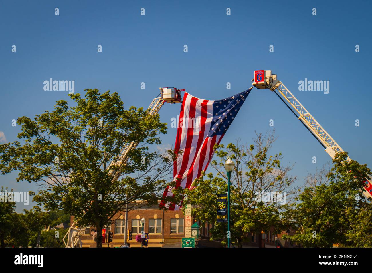 Newport, Vermont, USA - 8 agosto 2023: Appendere la bandiera americana sul percorso della parata con tutti i vigili del fuoco del Regno del Nord-Est Foto Stock