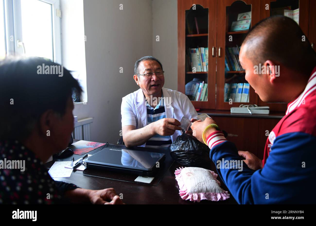 (170802) -- JILIN, 2 agosto 2017 -- Yue Ruhua (centrale) fornisce consulenza medica ai pazienti nel villaggio Dakouqin di Houtuanshan Town in Jilin City, provincia di Jilin della Cina nord-orientale, 31 luglio 2017. Il 64enne Yue Ruhua è un medico rurale da 37 anni. A differenza dei medici nelle aree urbane, i medici rurali devono effettuare spesso chiamate a domicilio. Secondo la moglie di Yue Ruhua, Jing Yuhong, cadde su una strada accidentata e rimase alzato fino a tardi per salvare i pazienti innumerevoli volte. Nel 2013, a Yue Ruhua è stato diagnosticato un infarto miocardico acuto e inviato in unità di terapia intensiva. Gli abitanti del villaggio hanno raccolto più di 20.000 yua Foto Stock