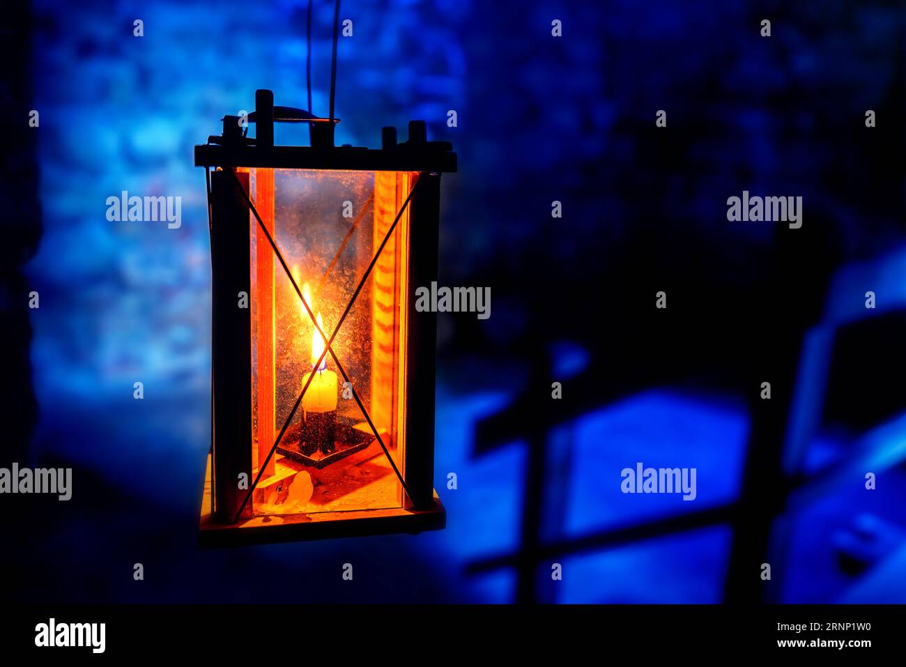 Luce delle Lanterne a candela su sfondo in pietra blu Foto Stock