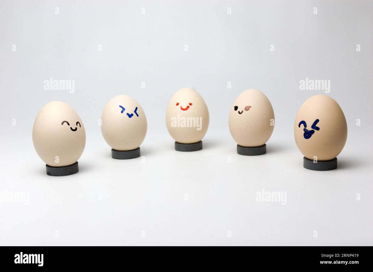 uova con emozione sorridente su sfondo grigio Foto Stock