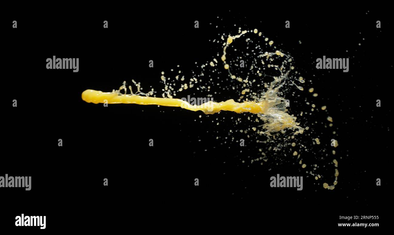 Il succo d'arancia esplode e spruzza su sfondo nero Foto Stock