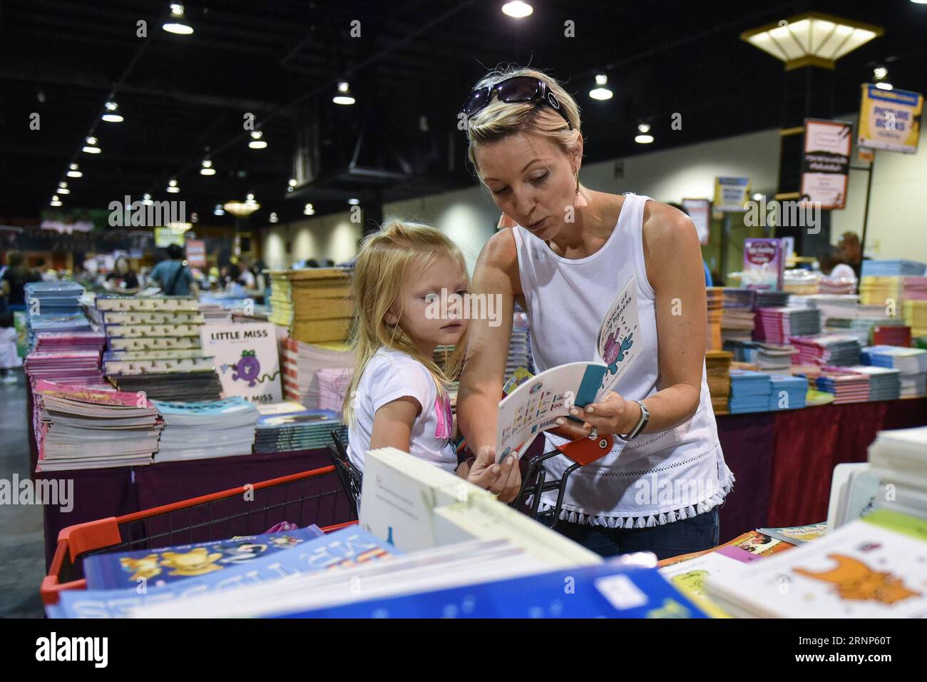 (170812) -- BANGKOK, 12 agosto 2017 -- Una donna e sua figlia hanno letto un libro per bambini durante la vendita di libri Big Bad Wolf a Bangkok 2017 presso l'IMPACT Muang Thong Thani Exhibition and Convention Center a Bangkok, Thailandia, 12 agosto 2017. La vendita di libri Big Bad Wolf ha avuto origine in Malesia è una delle più grandi del suo genere nel sud-est asiatico. Operativo 24 ore su 24 tutti i giorni dall'11 al 27 agosto, la sua versione 2017 di Bangkok vedrà in vendita oltre tre milioni di libri di oltre 40 categorie, con tassi di sconto dal 60% al 80%. ) (srb) THAILAND-BANGKOK-CONSUMER-BOOK-SALE LixMangmang PUBLICATIONxNOTxINxCHN Foto Stock