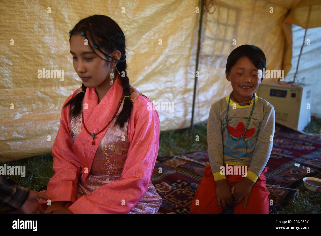 (170816) -- XIAHE, 16 agosto 2017 -- Deqen Yuzhen (L) parla con il fratello minore nella loro tenda nella prateria della sua città natale, Contea di Maqu, Prefettura autonoma tibetana di Gannan, provincia del Gansu della Cina nord-occidentale, 13 agosto 2017. Deqen Yuzhen, nata il 14 settembre 1998, è la figlia di una famiglia di pastori nella contea di Maqu, prefettura autonoma tibetana di Gannan, provincia del Gansu nella Cina nordoccidentale. Sfortunatamente ha perso la vista a causa di una grave malattia quando era piccola. È stata mandata alla scuola per bambini ciechi nella regione autonoma del Tibet nel sud-ovest della Cina all'età di nove anni e trasferita Foto Stock