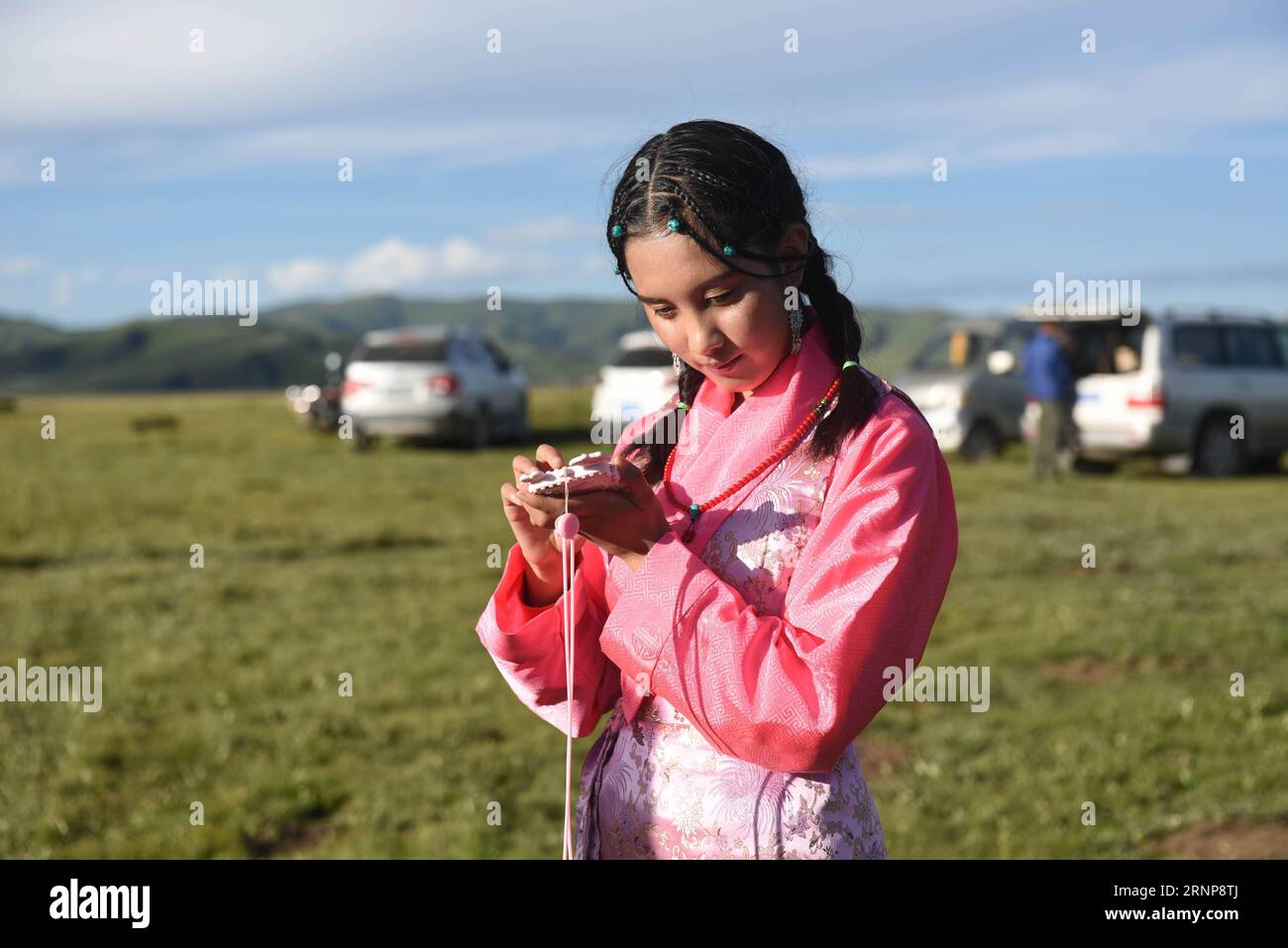 (170816) -- XIAHE, 16 agosto 2017 -- Deqen Yuzhen ascolta i messaggi con il suo cellulare sulla prateria della sua città natale, Contea di Maqu, Prefettura autonoma tibetana di Gannan, provincia del Gansu della Cina nord-occidentale, 13 agosto 2017. Deqen Yuzhen, nata il 14 settembre 1998, è la figlia di una famiglia di pastori nella contea di Maqu, prefettura autonoma tibetana di Gannan, provincia del Gansu nella Cina nordoccidentale. Sfortunatamente ha perso la vista a causa di una grave malattia quando era piccola. All'età di nove anni fu mandata alla scuola per bambini ciechi nella regione Autonoma del Tibet nel sud-ovest della Cina e trasferita a blino Foto Stock