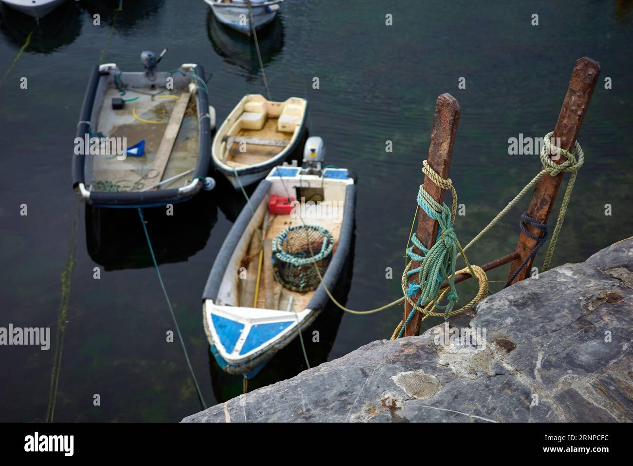 Piccole imbarcazioni, o tender per yacht più grandi, legate al muro del porto Foto Stock