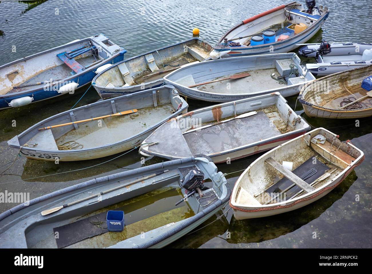 Piccole imbarcazioni, o tender per yacht più grandi, legate al muro del porto Foto Stock