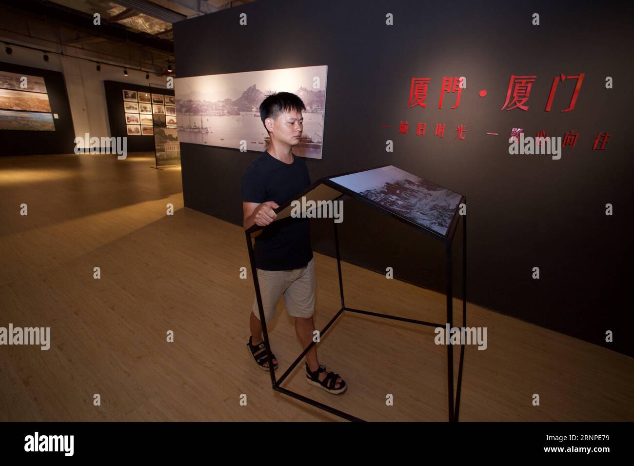 (170825) -- XIAMEN, 25 agosto 2017 -- Xue Shijie prepara la sua mostra fotografica a Xiamen, provincia del Fujian della Cina sud-orientale, 18 agosto 2017. Il 30enne Xue è un collezionista di foto di Xiamen. Dieci anni fa, è venuto a Xiamen e ha iniziato a scattare foto dello sviluppo della città nel suo tempo libero. Nel 2011, Xue ha visto le foto del file della città su Internet per caso. Ha iniziato a partecipare alle aste online e le ha comprate da altri collezionisti. L'uomo di Shanghang ha raccolto più di 4.000 foto di file della città costiera. Oltre alla raccolta di foto, Xue fa anche ricerche Foto Stock