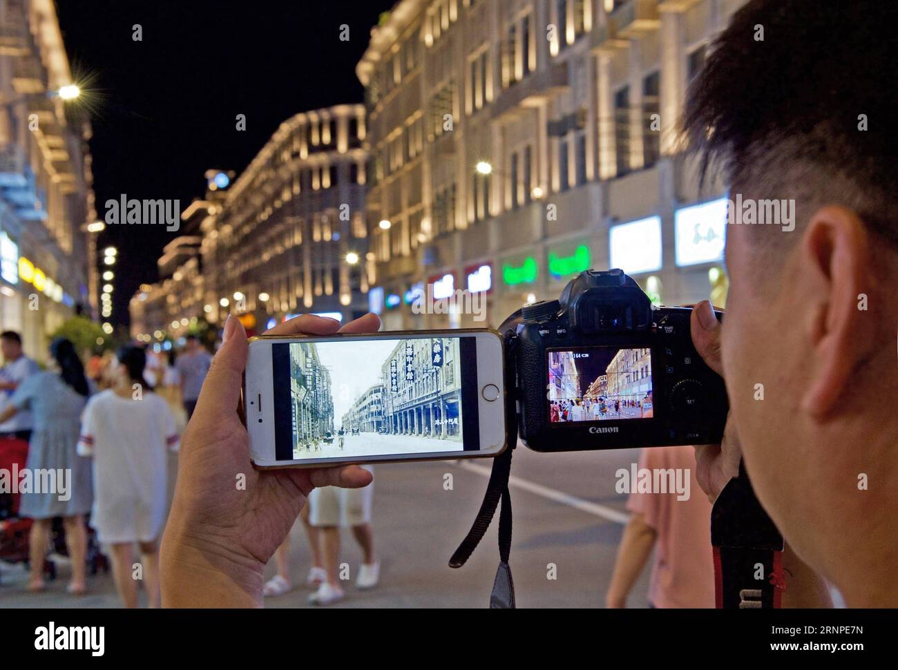 (170825) -- XIAMEN, 25 agosto 2017 -- Xue Shijie scatta foto e fa un confronto a Zhongshan Road a Xiamen, provincia del Fujian della Cina sudorientale, 16 agosto 2017. Il 30enne Xue è un collezionista di foto di Xiamen. Dieci anni fa, è venuto a Xiamen e ha iniziato a scattare foto dello sviluppo della città nel suo tempo libero. Nel 2011, Xue ha visto le foto del file della città su Internet per caso. Ha iniziato a partecipare alle aste online e le ha comprate da altri collezionisti. L'uomo di Shanghang ha raccolto più di 4.000 foto di file della città costiera. Oltre alla raccolta di foto, Xue si occupa anche di resettare Foto Stock