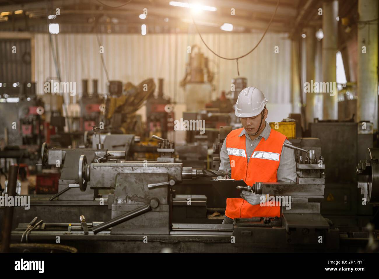 lavoratore maschio dell'ingegnere asiatico lavora nella fabbrica di fresatura del tornio della macchina del metallo pesante Foto Stock