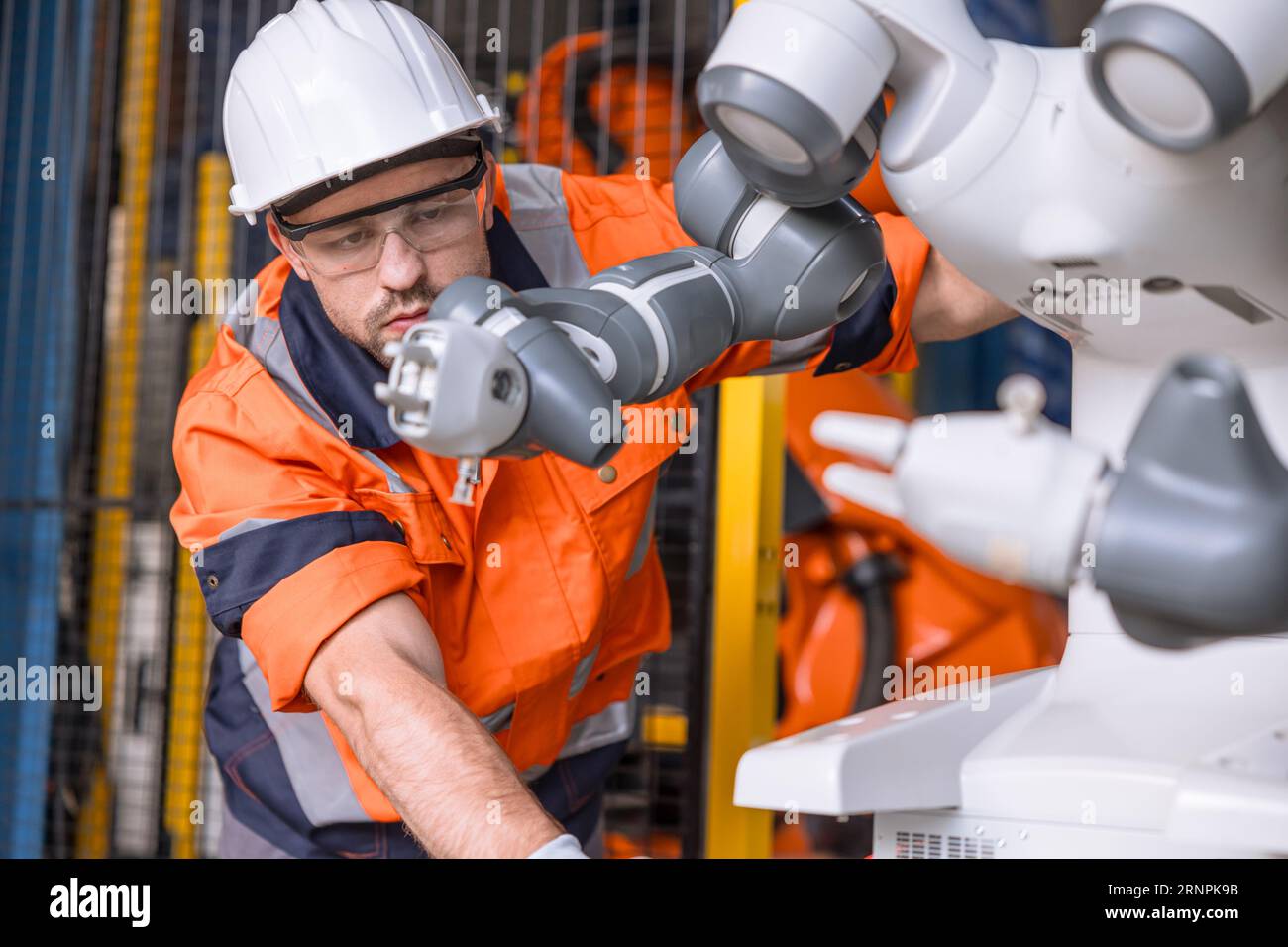 ingegnere professionale tecnico robotico controllo lavoro maschio anticipo di servizio selezionatore braccio robot ad alta precisione in fabbrica di automazione Foto Stock