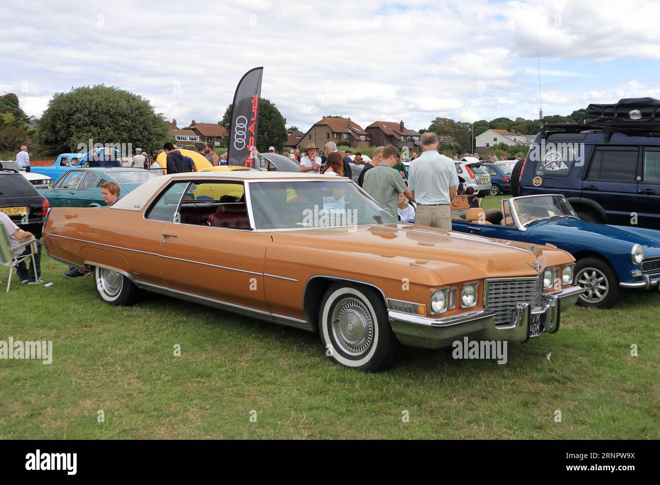 Orange c1970s Cadillac Coupe DeVille in mostra. Il Gosport Car Rally è organizzato dal Rotary Club locale e si svolge a Stokes Bay il lunedì festivo di agosto. L'evento di quest'anno, che offriva una giornata economica in famiglia, è stato il settantesimo e ha ospitato auto e moto d'epoca, un allevamento di animali domestici, bancarelle, rinfreschi e un'arena che ha fornito varie forme di intrattenimento. Foto Stock