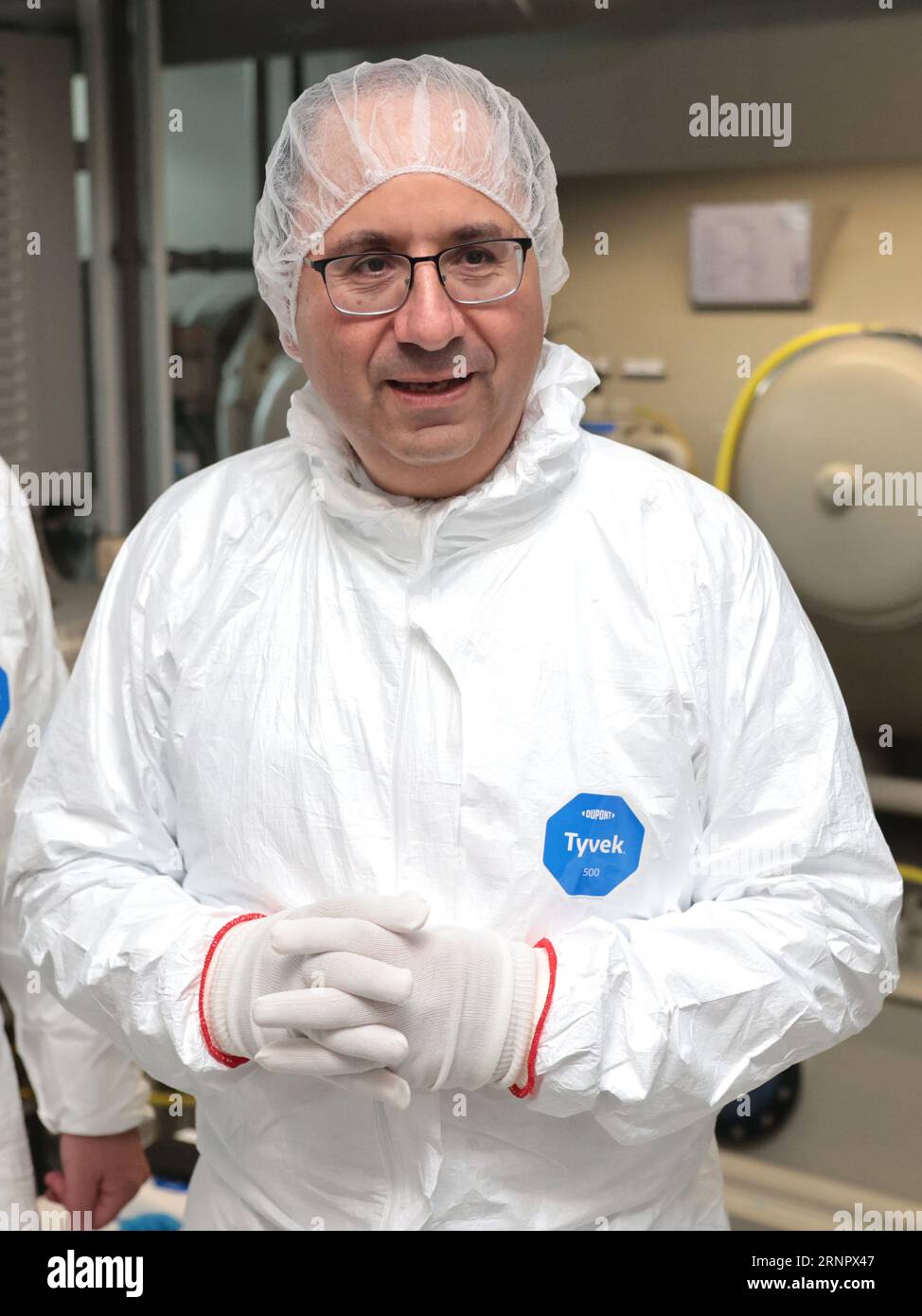 Magdeburg, Germania. 2 settembre 2023. Keyvan Esfarjani, Vicepresidente e membro del Consiglio di amministrazione di Intel, indossa una tuta protettiva nella camera bianca dell'Università otto von Guericke. La società sta investendo nel panorama universitario nella capitale dello stato. A partire dal prossimo semestre invernale, saranno disponibili fino a 40 posti presso l'università nel nuovo corso "Advanced Semiconductor and Nanotechnology". Credito: Peter Gercke/dpa-Zentralbild/dpa/Alamy Live News Foto Stock