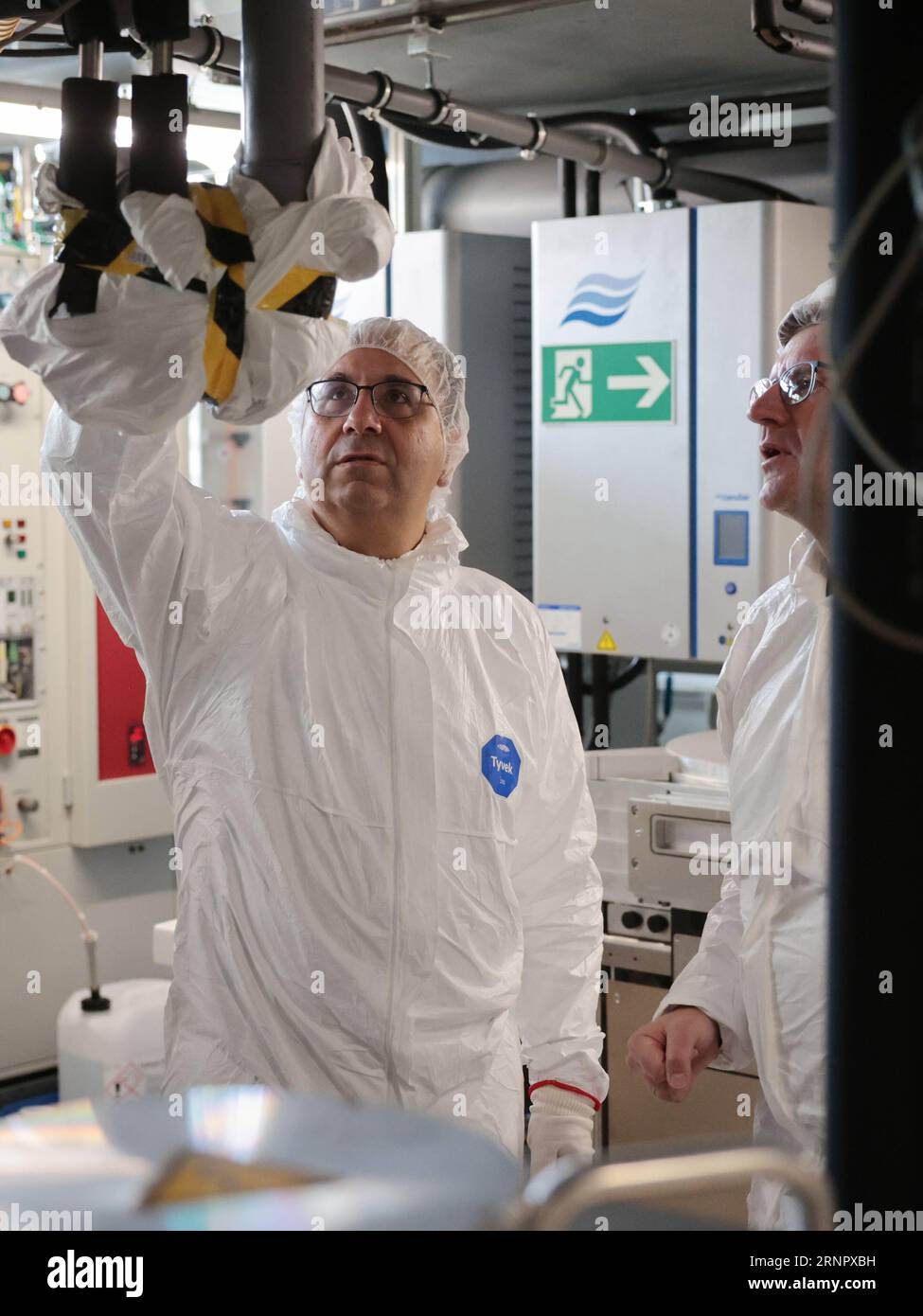 Magdeburg, Germania. 2 settembre 2023. Keyvan Esfarjani, Vicepresidente del Consiglio di amministrazione di Intel, visita le camere bianche dell'Università otto von Guericke con una tuta protettiva. La società sta investendo nel panorama universitario nella capitale dello stato. A partire dal prossimo semestre invernale, saranno disponibili fino a 40 posti presso l'università nel nuovo corso "Advanced Semiconductor and Nanotechnology". Credito: Peter Gercke/dpa-Zentralbild/dpa/Alamy Live News Foto Stock